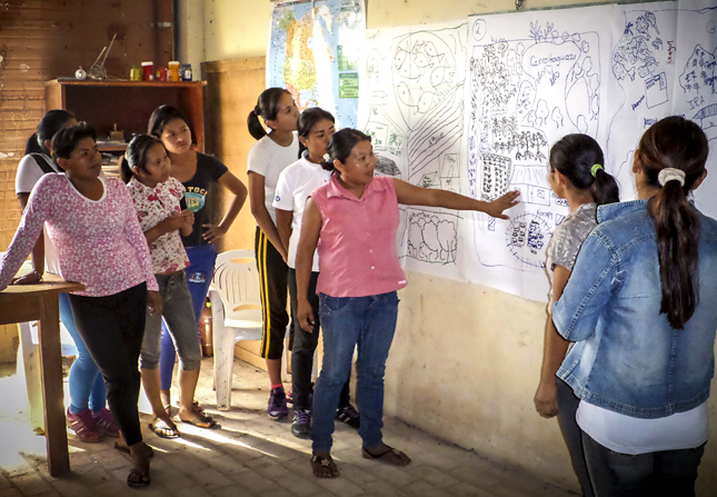 Zunilda Arce (center) and young women from the Ita Guasu indigenous community in Paraguay, participate in the development of their community development plan. This activity is part of USAID’s efforts to strengthen civil society participation in municipal governance. Through its local partner Federation of Production Cooperatives (FECOPROD), USAID also works with indigenous communities to help them identify and advocate for their needs within a political context. /Luciano González, FECOPROD
