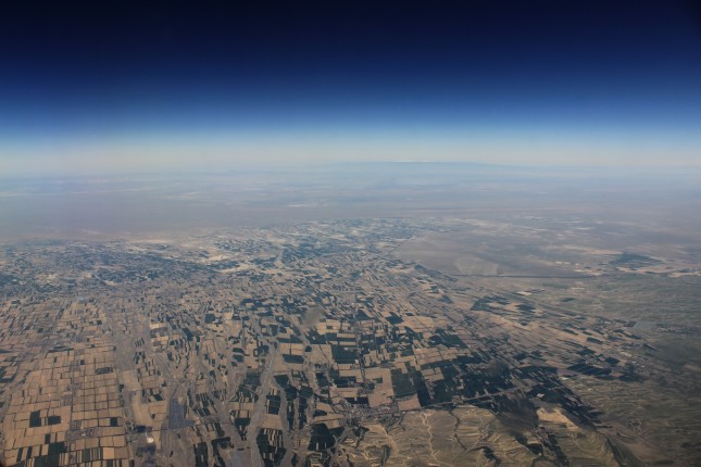 A bird’s eye view of Urumqi, seen from the plane. Patches of green can be seen amidst vast plots of desert, 2016, courtesy of Meredith Peng