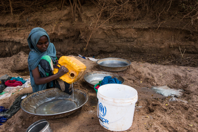 A woman washes her clothes in the Dawa River with three day old water dug from shallow wells in the riverbed, which is now the only source of water for IDP's living in Kansale IDP camp, Somalia, on MAR 24, 2017. The severe drought across Somalia and the Horn of Africa has caused a humanitarian crisis that threatens millions.