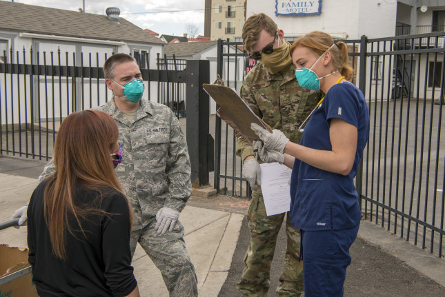 U.S. Air National Guard Tech. Sgt. Matt Miller, 140th Wing occupational safety specialist, and Airman 1st Class Ryan Terry, 233rd Space Warning Squadron security forces, assigned to Task Force Shelter Support for the Colorado National Guard’s COVID-19 response, discuss the status of support with the staff and a volunteer nurse Rebekah Maciorowski, at a motel where people without homes are lodged, Denver, Colo., April 10, 2020. Members of the Colorado National Guard volunteer to support state and local officials combat the Corona Virus Pandemic by assisting multiple agencies in the state of Colorado. (U.S. Air National Guard photo by Senior Master Sgt. John Rohrer)