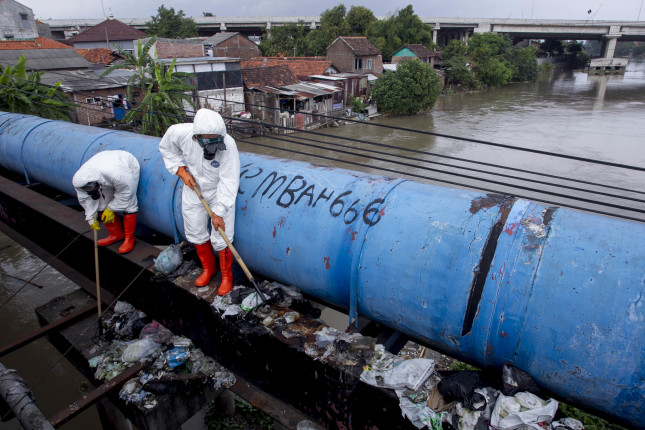 Waste cleaners working over a river