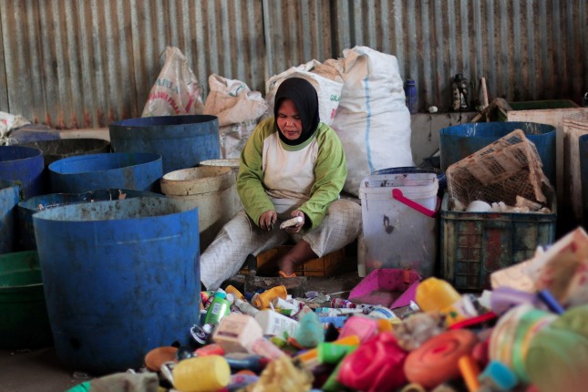 2ENBYE1 A collector sorts household waste plastic to be recycled at a waste shelter in Bogor, West Java, Indonesia, on July 23, 2019. Based on research released by McKinsey and Co. and Ocean Conservancy, Indonesia's number two producer of plastic waste after China. Recycling plastic waste becomes economic and business value.(Photo by Aditya Saputra / INA Photo Agency / Sipa USA)