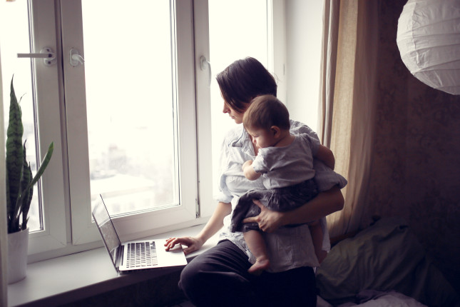 Mom,With,A,Baby,In,Her,Arms,Working,On,A