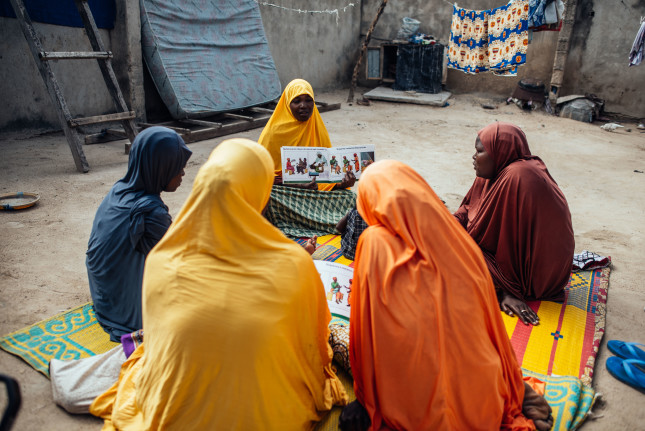 Hauwa Mustapha, 30, interacts with other women during mother-mother session within their community at Sulubri, Maiduguri, Borno, Nigeria, on saturday, 25 September 2021 Photo by KC Nwakalor for IRC Hauwa Mustapha, 30, is a community based exclusive breastfeeding advocate. She often goes around in her community speaking to other mothers or soon to be mothers about the benefits of exclusive breastfeeding, educating them on healthy locally-sourced foods to avoid severe acute malnutrition in their children and other best practices in looking after new-borns. As part of IRC’s sustainability measures towards eradicating severe acute malnutrition in children, mothers were trained in various skill acquisition programs and provided with tools needed to kickstart their journey towards economic independence; if mothers had means of livelihood, they would ultimately provide the nutritional needs for their babies.  These assistance included (but not limited provision) of sewing machines, seedlings for farming and capital grants to start small businesses.